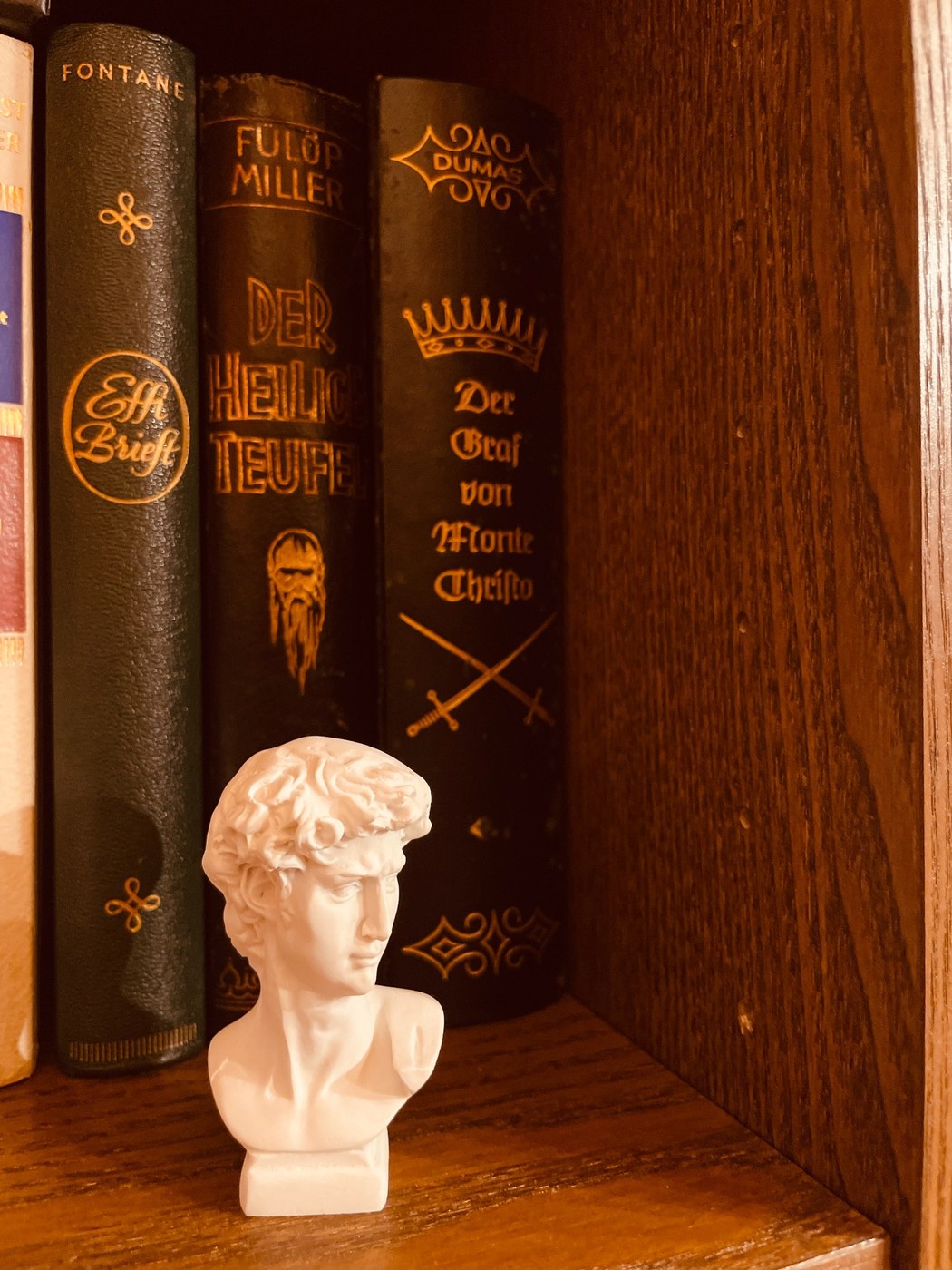 Kleine klassische Büste vor Büchern in der Bibliothek